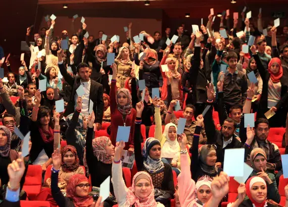 NDI Debate-Audience hold up cards to vote for the debate team from Yarmouk University, winner of Jordan's first-ever national student debate competition_Debating on allowing parties to operate in universities.JPG