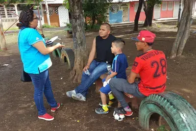 A youth organizer surveys members of the community about the most pressing issues affecting their neighborhood.